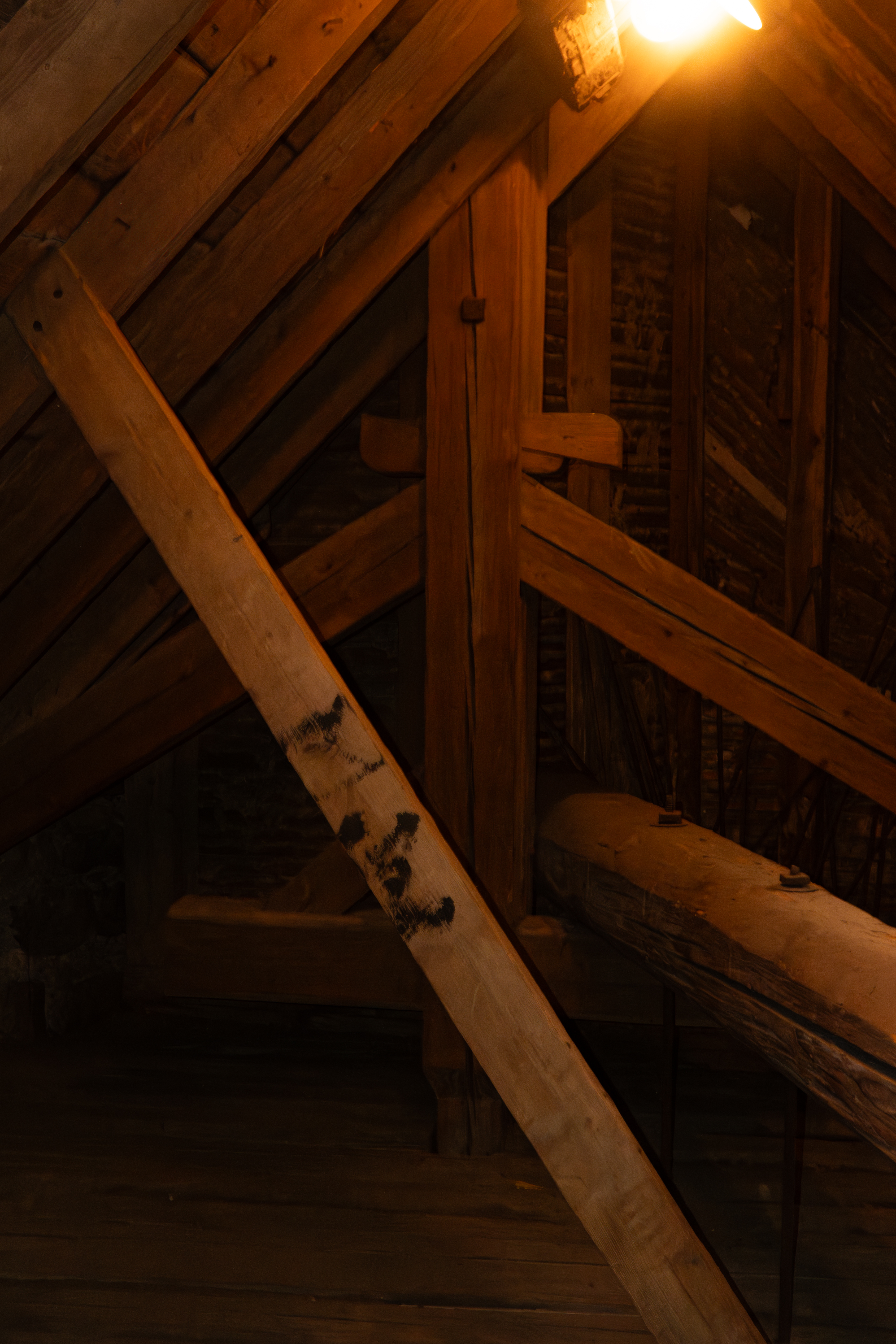 Dachboden aus Holz, warm beleuchtet, Spuren von Nutzung